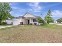 Charming single-story home with a cozy front porch, attached garage, and beautifully landscaped front yard at 7838 Long Shadow Ln, North Charleston, SC 29406