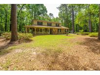 Charming two-story home with brick facade and welcoming front porch surrounded by lush greenery at 110 Cantering Hills Ln, Summerville, SC 29483