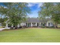 Charming one-story home with well-manicured lawn and inviting front porch at 127 Travis Hill Rd, Moncks Corner, SC 29461