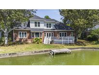 Charming two-story brick home with a white deck and a private dock on the water at 1280 Waterfront Dr, Mount Pleasant, SC 29464