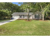 Charming single-story home featuring a well-manicured lawn, a driveway, and classic curb appeal at 1445 Downwood Pl, Charleston, SC 29412