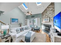 Bright living room boasts a vaulted ceiling, fireplace, skylights and comfortable seating for relaxation at 166 River Breeze Dr, Charleston, SC 29407