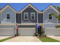 Charming townhome exterior featuring multiple garages, craftsman details, and American and South Carolina flags at 2648 Balena Dr, Mount Pleasant, SC 29466