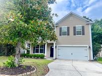 Charming two-story home features a well-manicured lawn, attached garage, and neutral siding at 3632 Locklear Ln, Mount Pleasant, SC 29466