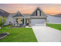 Charming home with a manicured lawn, covered porch, and a two-car garage at 413 Eagleview Dr, Moncks Corner, SC 29461