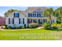 Charming two-story home with a manicured lawn and mature palm trees at 4227 Sawgrass Dr, North Charleston, SC 29420