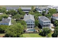 Beautiful aerial view of the home showcasing its pool, well-manicured lawn, and proximity to neighboring houses at 764 Post Oak Dr, Mount Pleasant, SC 29464