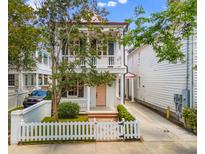 Charming two-story home with a white picket fence and inviting front porch and a pink front door at 80 Smith St, Charleston, SC 29401