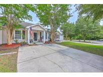 Charming single-story home featuring a spacious driveway, manicured lawn, and inviting front porch at 8028 Vermont Rd, North Charleston, SC 29418