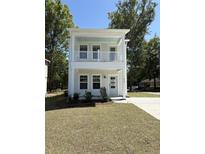 Charming two-story home featuring a welcoming porch and a well-maintained front yard at 819 Burger St, Charleston, SC 29407