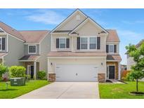 Charming two-story home featuring a two-car garage, well-manicured lawn, and inviting curb appeal at 9923 Honeylocust Ln, Ladson, SC 29456