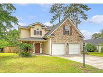 Inviting two-story home featuring a two-car garage, manicured lawn, and mature trees under a partly cloudy sky at 1042 Cobblestone Blvd, Summerville, SC 29486