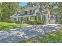 Charming two-story home with a welcoming front porch and well-manicured landscaping at 121 Woodland Dr, Summerville, SC 29485