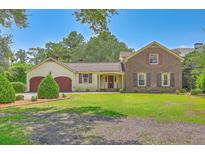 Charming brick home with a lush front lawn, two-car garage, and shuttered windows at 17 Johnson Rd, Charleston, SC 29407