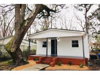 Charming home with a welcoming front porch, brick foundation and a mature tree at 1925 Kerry St, North Charleston, SC 29406