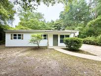 Charming single-story home with vinyl siding and a welcoming front entrance, nestled in a lush, wooded setting at 208 Orange St, Walterboro, SC 29488