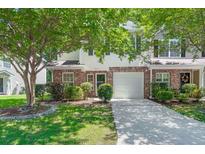 Charming two-story home featuring a single-car garage, brick accents, and a well-maintained front yard with lush trees at 215 Jackson St, Goose Creek, SC 29445