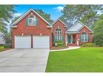 Charming two-story red brick home with a well-manicured lawn, two-car garage and inviting curb appeal at 416 Prestwick Ct, Summerville, SC 29483
