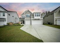 Two-story home with gray siding, a two-car garage, and a well-manicured lawn for great curb appeal at 436 Rowley Ln, Summerville, SC 29486