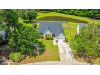 Charming home with well-manicured lawn and a pond view, complete with an attached single-car garage and mature trees at 5128 Thornton Dr, Summerville, SC 29485