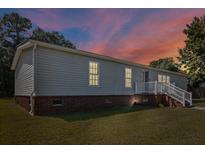 Charming single-Gathering home featuring vinyl siding, brick foundation and a cozy front porch with white railing at 513 Pauline Dr, Bonneau, SC 29431