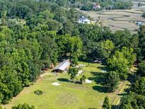 Expansive wooded property with a horse barn, paddock, and fenced training ring near winding creeks at 6434 Saint Anthony Dr, Meggett, SC 29449