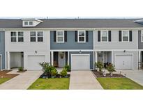Charming townhome exteriors feature multi-toned siding, attached garages, and manicured landscaping at 768 Trotters Ln, Moncks Corner, SC 29461
