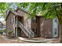 Two-story condo featuring wood siding and a stairway leading to the upper level entrance at 7935 Parklane Ct # A, North Charleston, SC 29418