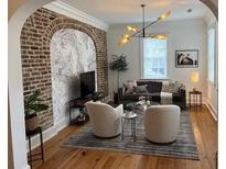 Bright living room features exposed brick, hardwood floors, and plenty of natural light at 84 Bull St # F, Charleston, SC 29401