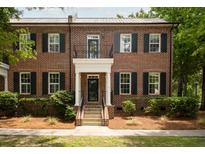 Charming brick townhome featuring a covered entryway, black shutters, and manicured landscaping at 861 Center Park St, Charleston, SC 29492