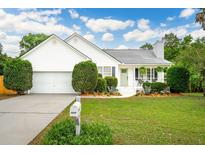 Charming single-story home with a well-manicured lawn, white siding, and an attached garage at 1077 Farmington Rd, Charleston, SC 29412