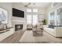 Bright living room with a fireplace, lots of natural light, and a cozy atmosphere at 130 River Landing Dr # 2310, Daniel Island, SC 29492