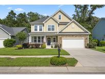 Charming two-story home featuring a manicured lawn, stone accents, and a cozy front porch with a white railing at 132 Daniels Ridge Dr, Summerville, SC 29485