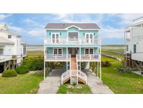 Two-story coastal home featuring a blue exterior, white railings, and a welcoming stairway at 1568 E Ashley Ave, Folly Beach, SC 29439