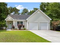 Charming one-story home with light green siding, well-manicured lawn, and an attached two-car garage at 1578 Stanwick Dr, Johns Island, SC 29455