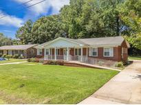 Charming red brick home with well-manicured lawn and inviting front porch at 1593 Teague St, Charleston, SC 29407