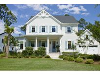 Charming two-story home featuring light blue shutters, a welcoming front porch, and beautifully landscaped yard at 1723 Bolden Dr, Mount Pleasant, SC 29466