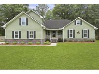 Charming home featuring green siding, black shutters, and a lush green lawn at 189 Fox Chase Dr, Goose Creek, SC 29445