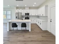 Bright kitchen with white cabinets, stainless steel appliances, and an island with bar stool seating at 1906 Gumwood Blvd, North Charleston, SC 29406
