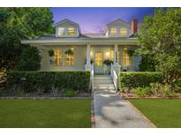 Charming two-story home featuring a well-manicured lawn and inviting front porch with elegant columns and dormer windows at 2060 Wappoo Hall Rd, Charleston, SC 29412