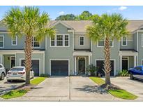 Inviting townhome with a well-kept lawn and beautiful palm trees enhancing its curb appeal at 2488 Stadium Dr, North Charleston, SC 29406