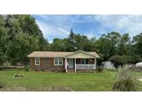 Charming single-story home with a brick facade, a covered porch, and a well-maintained front yard under a partly cloudy sky at 277 Carolina Cir, Walterboro, SC 29488
