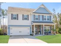 Charming two-story home with blue and white siding, attached garage, and well-manicured lawn at 301 Dunlin Dr, Summerville, SC 29486