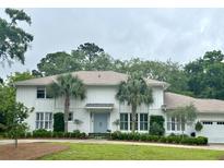 Charming two-story home with a well-manicured lawn, palm trees, and a light-blue front door at 37 Fort Royal Ave, Charleston, SC 29407