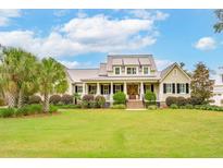 Expansive home featuring a large lawn, well-manicured landscaping, and inviting front porch at 4215 Ten Shillings Way, Ravenel, SC 29470