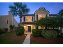 Charming two-story home with a well-manicured lawn and a beautiful palm tree at dusk at 4823 Shady Tree Ln, Summerville, SC 29485