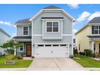 Charming two-story home with blue siding, well-manicured lawn, and a two car garage at 512 Alderly Dr, Moncks Corner, SC 29461