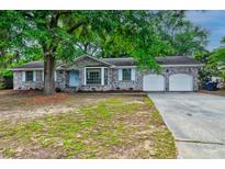 Charming brick home with a two-car garage and mature landscaping offers great curb appeal at 5322 Chantilly Ln, North Charleston, SC 29418