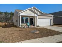 Charming home featuring beige siding, a two-car garage, and a welcoming front porch with colorful seating at 576 Polaris Way, Summerville, SC 29486