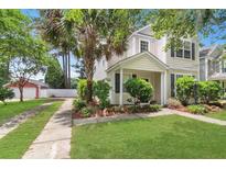 Charming two-story home featuring a well-manicured lawn and lovely landscaping with trees and shrubs at 8967 N Red Maple Cir, Summerville, SC 29485